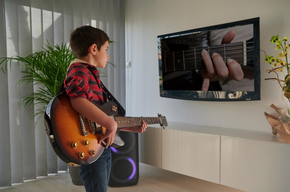 child-learning-play-electric-guitar-home-front-tv-online-elearning
